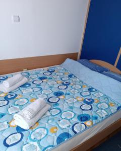 a bed with two pillows on top of it at Apartman MIKA in Zaječar