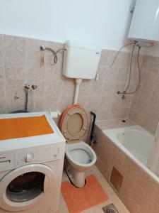 a bathroom with a toilet and a washing machine at Apartman MIKA in Zaječar