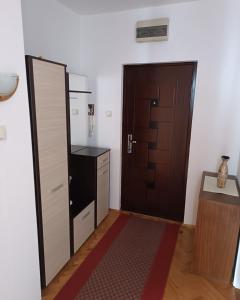 a small room with a door and a kitchen at Apartman MIKA in Zaječar