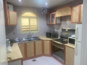 a kitchen with a sink and a stove top oven at شاليه in Rusibah