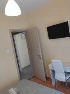 Cette chambre dispose d'une porte, d'un bureau et d'une horloge. dans l'établissement Papoulias Suite, à Thessalonique