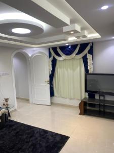 a living room with a tv and a door at شاليه in Rusibah