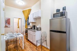 ニューヨークにあるCozy 2BD Stylish Home for Rentのキッチン(冷蔵庫、テーブル、椅子付)