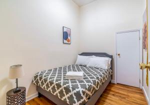 Schlafzimmer mit einem Bett mit einer schwarzen und weißen Bettdecke in der Unterkunft Cozy 2BD Stylish Home for Rent in New York
