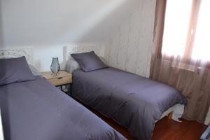 2 Betten neben einem Fenster in einem Schlafzimmer in der Unterkunft L' ESCALE SINAGOTE Chambre d'hôtes in Séné