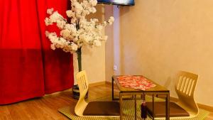 a dining room with a table and chairs and a tree at Little Japan in Roubaix