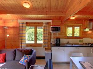 ein Wohnzimmer mit einem Sofa und einer Küche in der Unterkunft Geniet van het leven.. in De boomklever in Diffelen