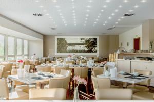 a dining room with white tables and chairs at Sonnenhotel Feldberg am See mit Schwimmbad, Sauna und Dampfbad in Feldberg