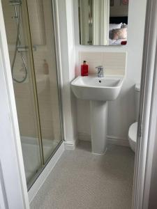 een badkamer met een wastafel en een douche bij Lovely 2 Bed, detached home. in Seacroft