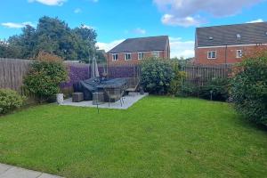 a backyard with a table and chairs in the grass at Lovely 2 Bed, detached home. in Seacroft