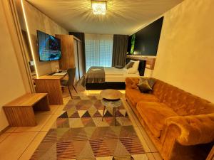 ein Wohnzimmer mit einem Sofa und einem Bett in der Unterkunft Boardinghouse HOME - adults only - in Konstanz