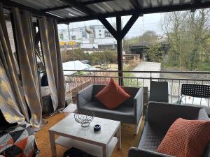 balcón con sofás, mesa y vistas en Schönes Zimmer in Bahnhofsnähe in einer Wohnung mit großer Terrasse en Gießen