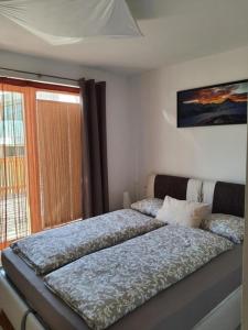 1 cama grande en un dormitorio con ventana en Chesa Vista Mezdi 6 Bergbahnen Sommer und ÖV inklusive en Pontresina
