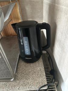 uma cafeteira preta em cima de uma prateleira em Schönes Zimmer in Bahnhofsnähe in einer Wohnung mit großer Terrasse em Giessen