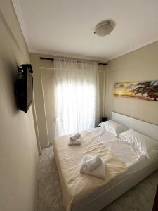 a bedroom with a bed with two towels on it at Seaside Apartment Aliki in Kallithea Halkidikis