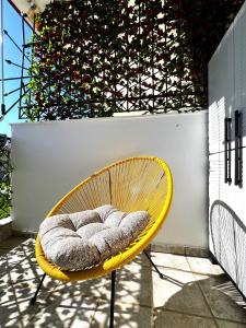 a yellow chair with a pillow on a patio at Seaside Apartment Aliki in Kallithea Halkidikis +21 photos