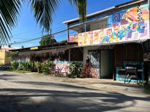 a building with graffiti on it next to a street at Backpacker Puerto Viejo in Puerto Viejo