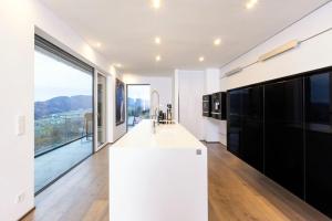 a kitchen with a white counter and large windows at Luxus Wohnung mit Panoramablick in Mondsee