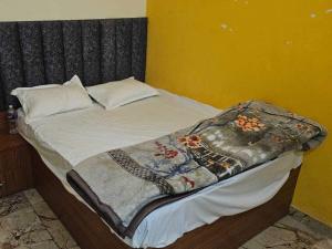 Una cama con una manta encima. en OYO Hotel Highway ON, en Meerut