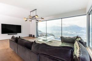 a living room with a couch and a large window at Luxus Wohnung mit Panoramablick in Mondsee