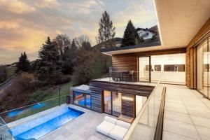 a house with a swimming pool and a balcony at Luxus Wohnung mit Panoramablick in Mondsee