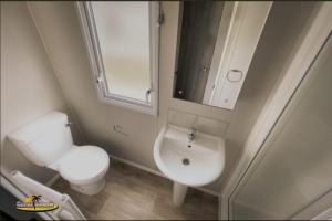 a bathroom with a sink and a toilet and a mirror at Coral Beach Ingoldmells 8 berth caravan FAMILY RAN in Ingoldmells