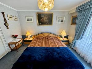 a bedroom with a large blue bed with two lamps at Chlösterli in Lucerne