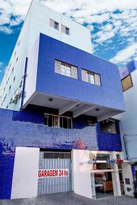 un edificio con azulejos azules en el costado. en Hotel Maia, en Betim