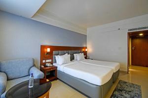 a hotel room with a large bed and a couch at Palette Madhapur in Hyderabad +45 photos