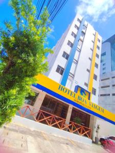 a hotel lax kerala building with a tree in front of it at Hotel Boa Viagem Aeroporto in Recife