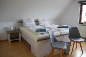 1 dormitorio con 1 cama con 2 sillas en Idyllische Ferienwohnung in Seefeld, en Norderaussendeich