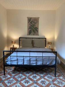 uma cama num quarto com duas lâmpadas em duas mesas em Maisonnette de plain-pied plein cœur du perche em Igé