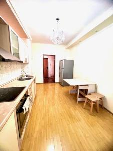 a kitchen and dining room with a table and refrigerator at 7 Очень теплая и уютная квартира возле Байтерека для 1-4 чел кровать и диван in Astana