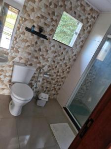 a bathroom with a toilet and a walk in shower at Suite independente com garagem prox à praia da Vila in Saquarema
