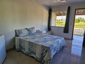 a bedroom with a bed and a large window at Suite independente com garagem prox à praia da Vila in Saquarema