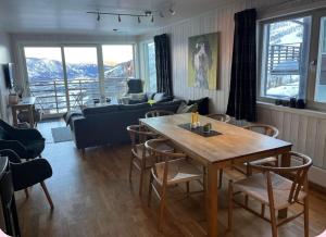 sala de estar con mesa de madera y sillas en Skarsnuten Panorama 61, Hemsedal en Hemsedal