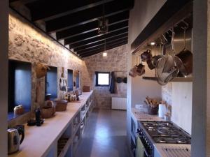 a large kitchen with white counters and a stove at Luxurious secluded villa in Calaceite