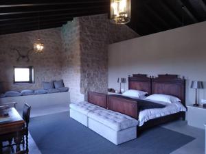 um quarto com uma cama grande e um sofá em Luxurious secluded villa em Calaceite