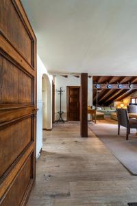 a hallway with a large wooden door and a living room at Chesa Ste Attic - Celerina in Celerina