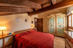 a bedroom with a red bed and a wooden cabinet at Chesa Ste Attic - Celerina in Celerina