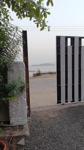 a gate on a beach with the ocean in the background at Tamboo O Zone / Dream Beach House in Murud