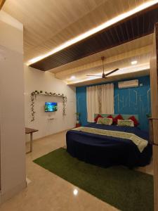 a bedroom with a bed and a blue wall at Tamboo O Zone / Dream Beach House in Murud