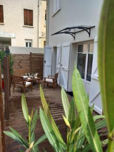 a patio with a table and benches on a building at LA TERRASSE in Luchon