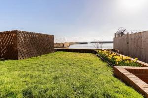 a backyard with a fence and some grass and flowers at Stunning Ground Floor Hartlepool Marina Apartment in Hartlepool