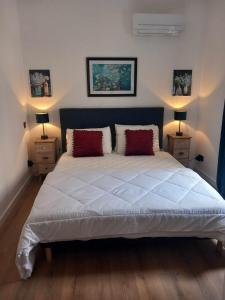 a bedroom with a large white bed with two night stands at LA TERRASSE in Luchon