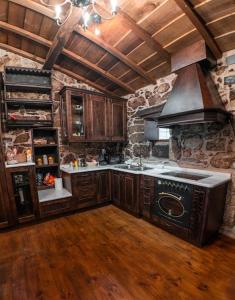 uma cozinha com um fogão e uma parede de pedra em Os Queixeiros Rural House em Chantada