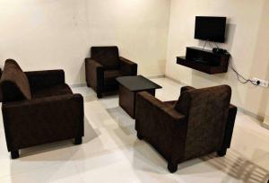 a living room with two chairs and a tv at SKYLARK STUDIO 1 in Belgaum