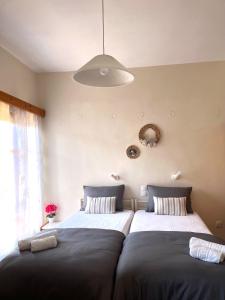 Dos camas una al lado de la otra en un dormitorio. en Nicoll Apartments, en Acharavi