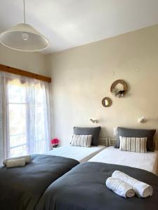 dwa łóżka siedzące obok siebie w sypialni w obiekcie Nicoll Apartments w Acharavi