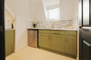 a kitchen with green cabinets and a sink at Garmoyle Road Flat 3 in Liverpool